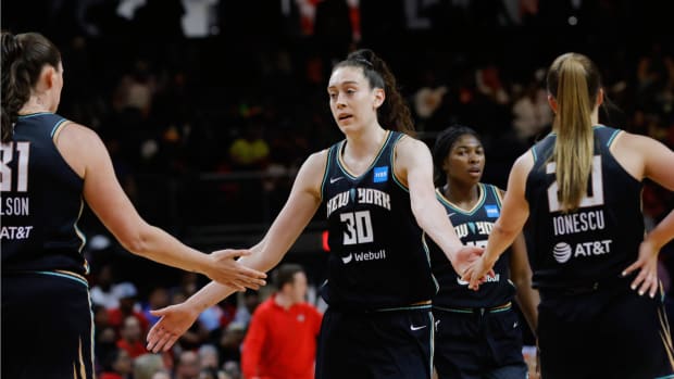 Liberty forward Breanna Stewart high fives her teammates center Stefanie Dolson and guard Sabrina Ionescu during a game in 2023.